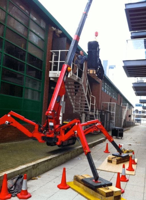 A red mini spider crane on the job for conspicious areas in the United States